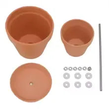 Losse onderdelen van de terracottakleurige SfeerDome: twee kappen, schaal en metalen bevestigingsmateriaal