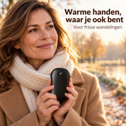 Vrouw houdt de zwarte WarmGrip handwarmer vast tijdens een frisse wandeling
